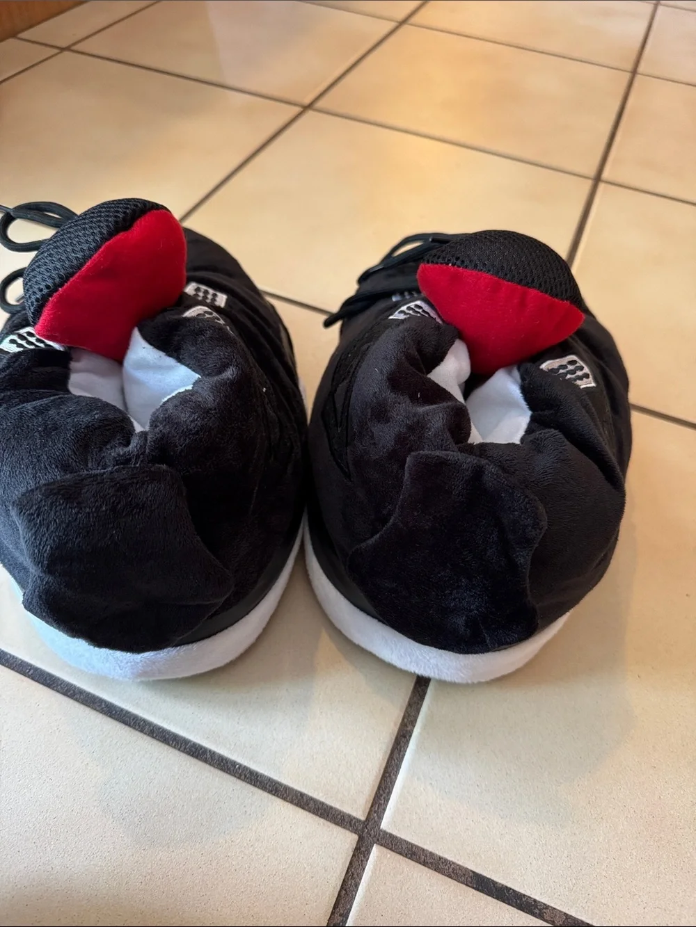Air Jordan Kids Black and Red fuzzy slippers.